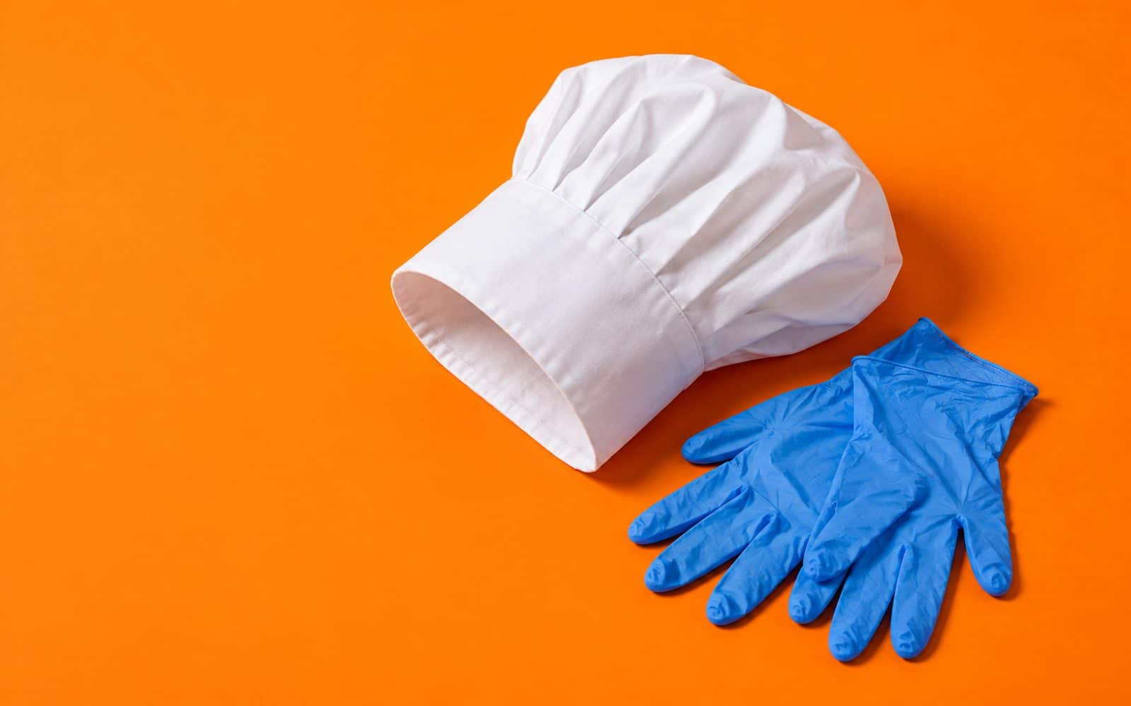 Toque de cuisinier blanche et gants en nitrile bleus