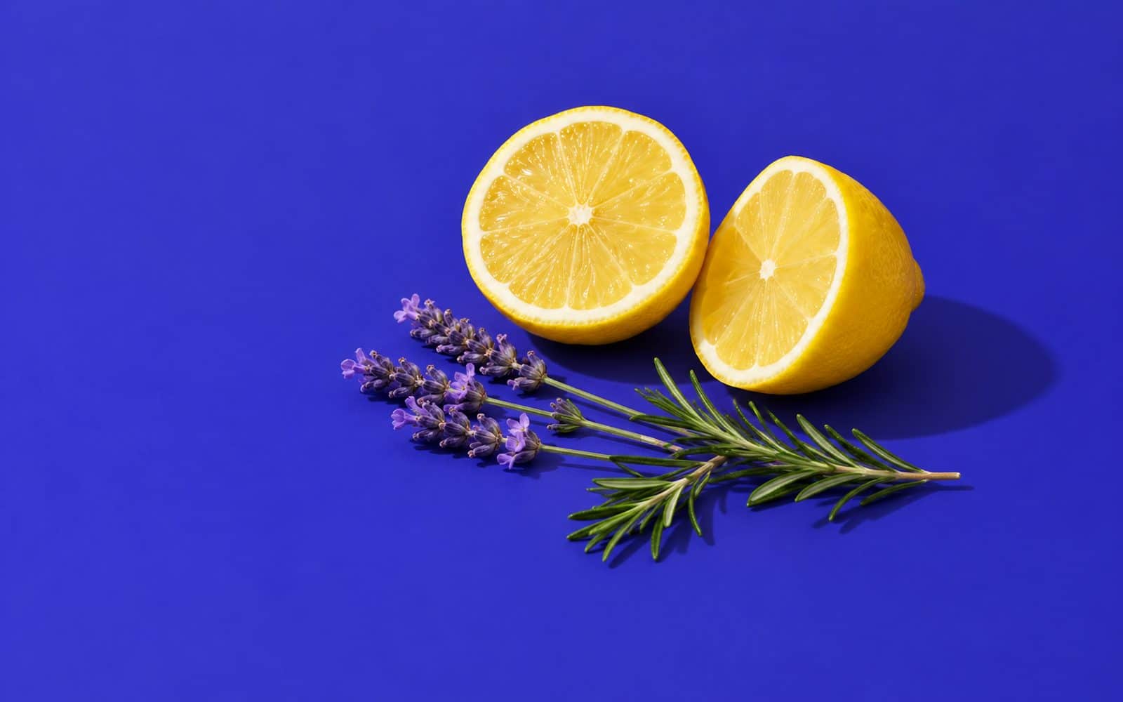 Citron coupé en deux, brins de lavande et de romarin