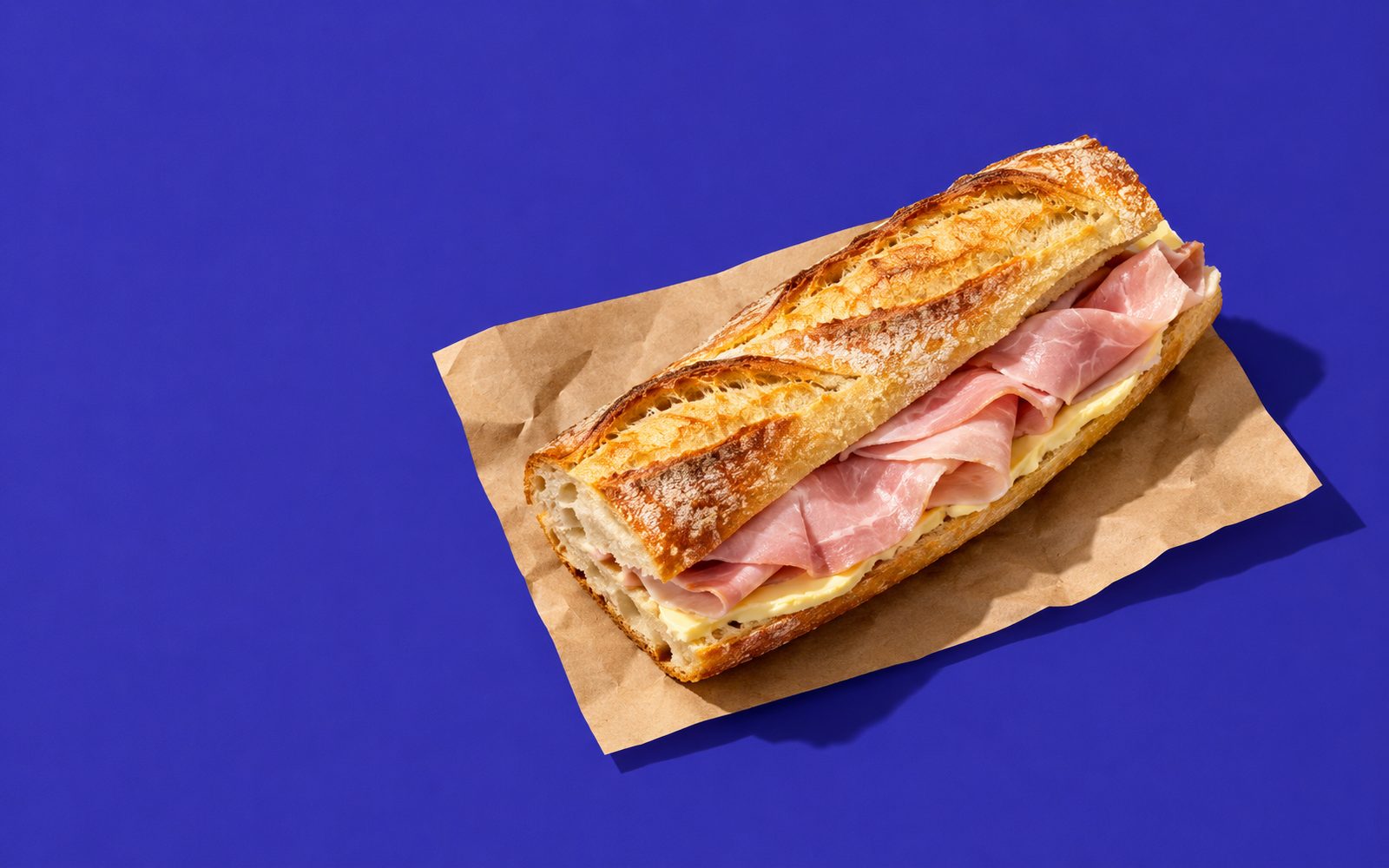 Sandwich jambon-beurre en demi-baguette sur papier kraft
