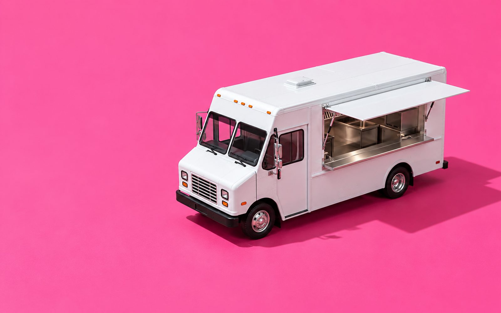 Camion-restaurant blanc, guichet ouvert sur une cuisine en inox