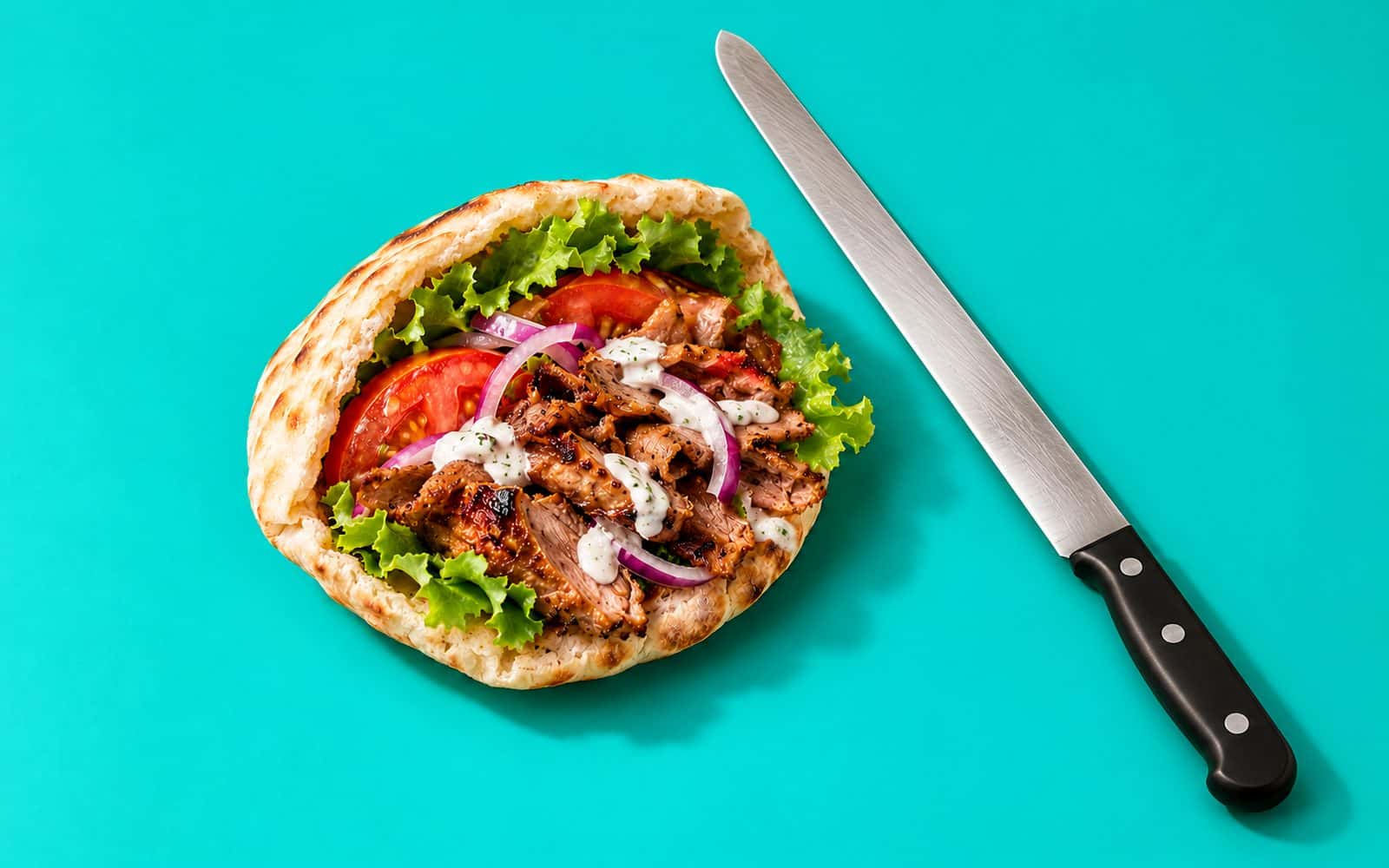 Pita garni de viande grillée et de crudités, couteau à kebab