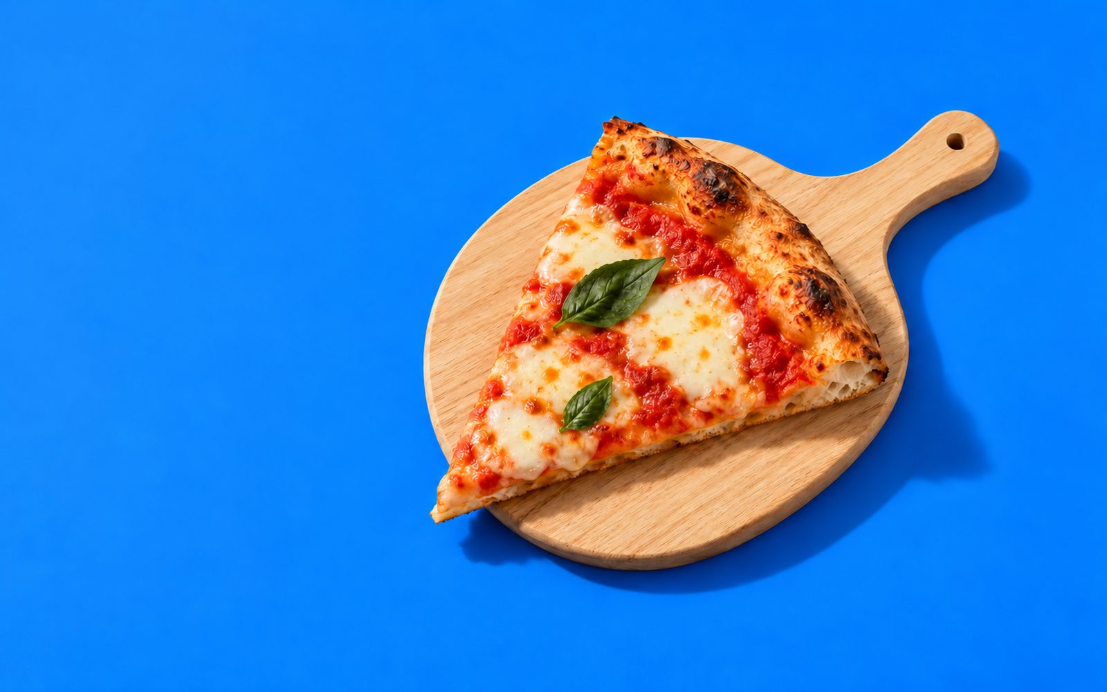 Part de pizza margherita sur une pelle en bois
